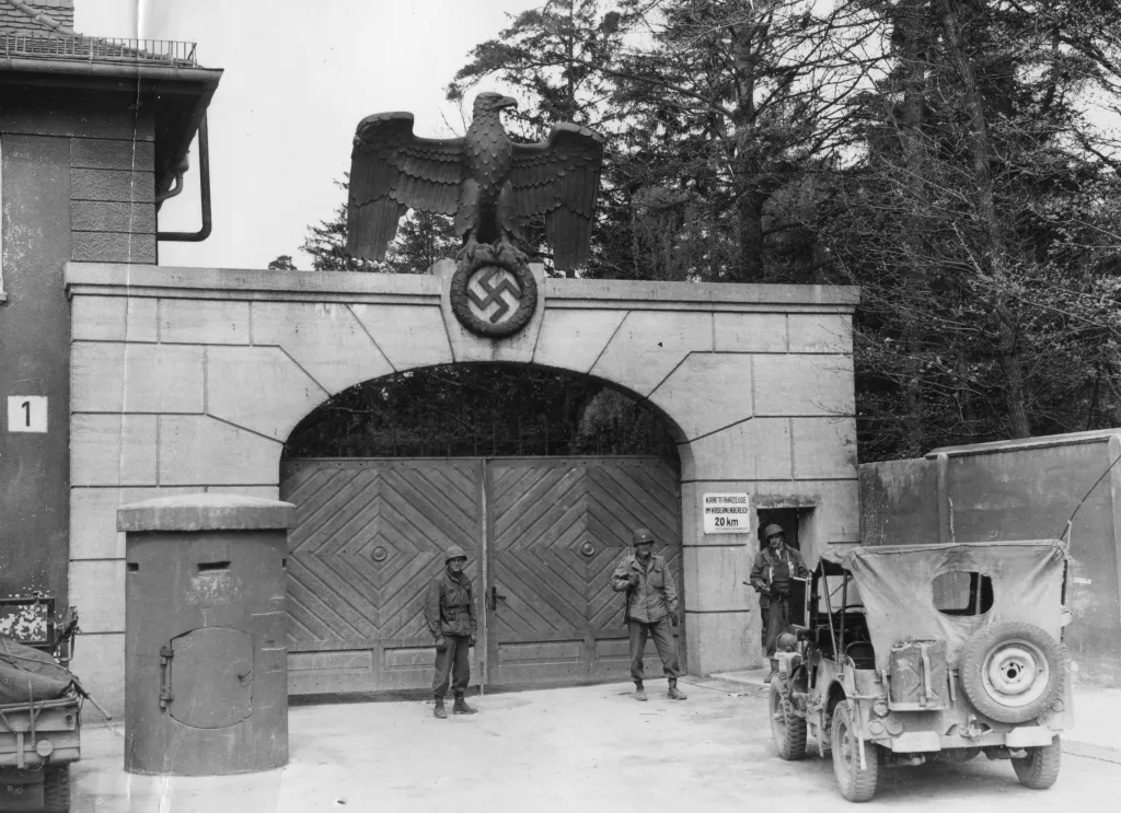 American soldiers stand before the gates of the main entrance to the Dachau Concentration Camp in Dachau, Germany, in 1945. 