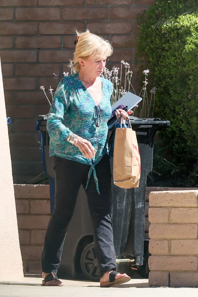 Linda Purl carrying her birthday cake in a brown paper bag.