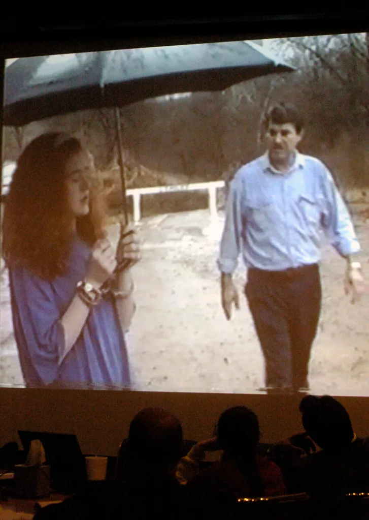 Christa Pike, center, and attorney Donald E. Dawson, left, watching a video of Pike at the scene of the murder.