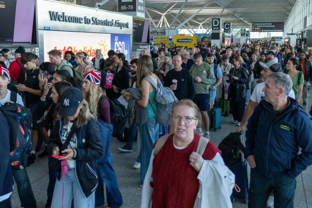 Passengers queue at Stansted Airport during widespread flight disruptions.