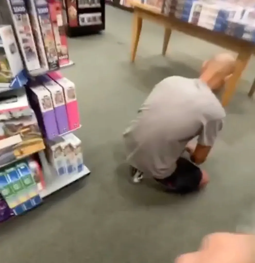 Man Calese Carron Crowder bending down in a bookstore.