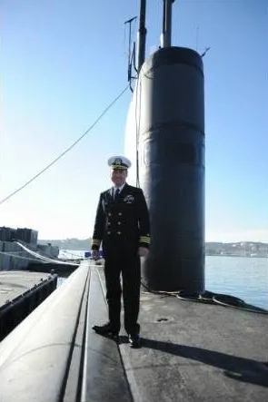 Christian Bradley Williams in a naval uniform standing on a submarine.