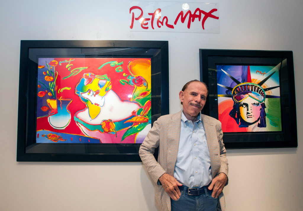 Artist Peter Max posing in front of his pop art.