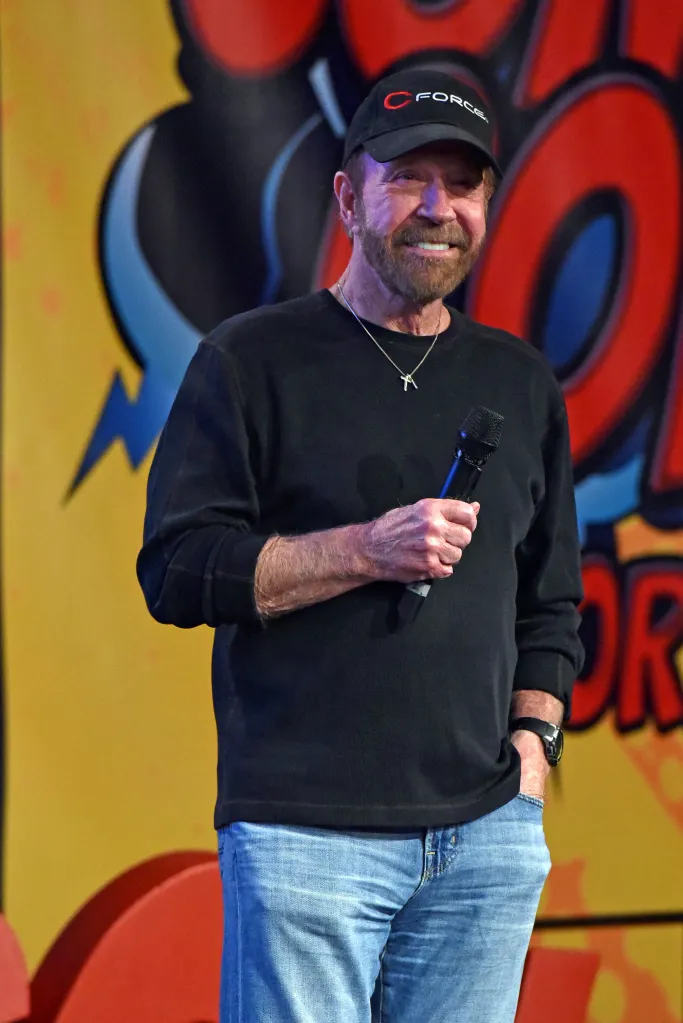Chuck Norris smiling and holding a microphone at German Comic Con.