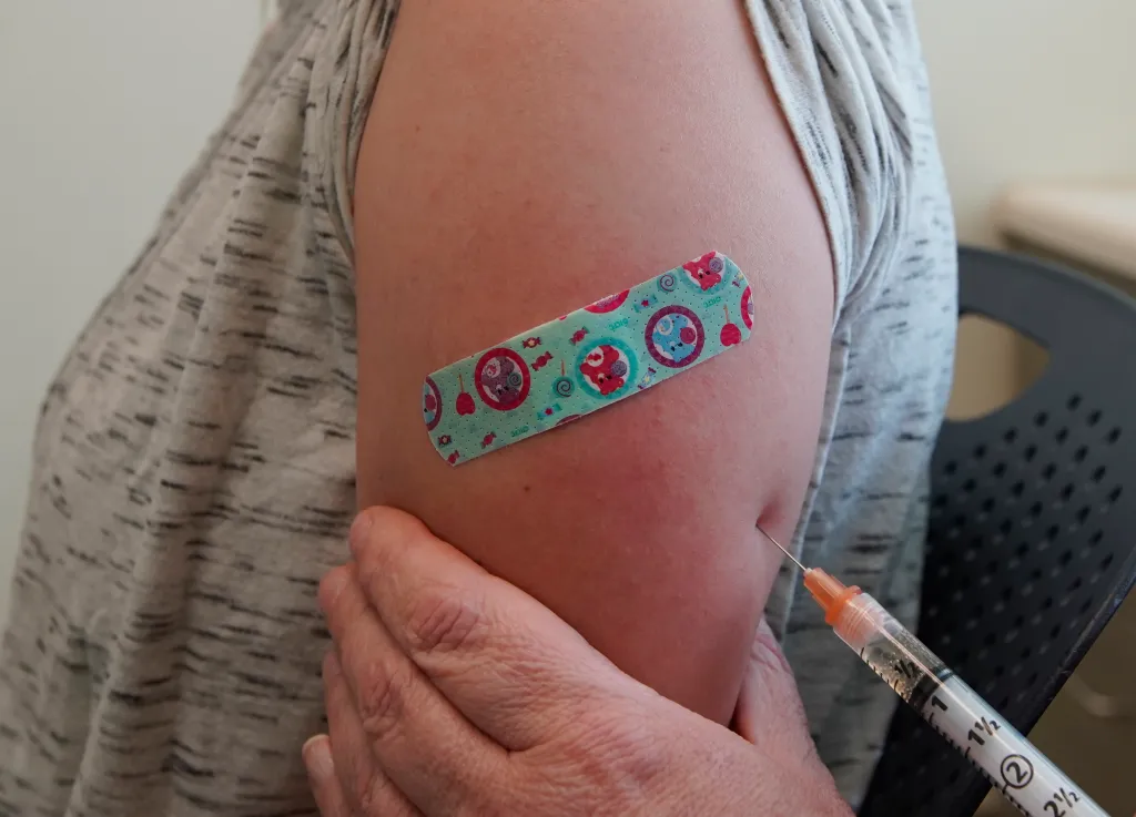 A nurse administers a measles, mumps, and rubella vaccine to a patient.