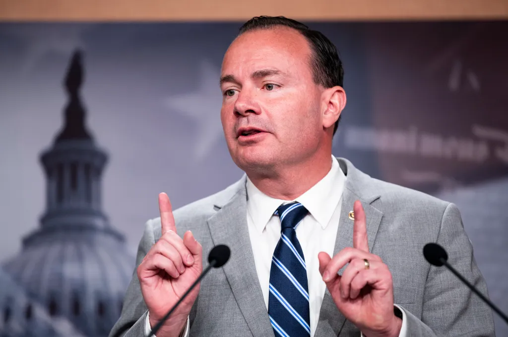 Sen. Mike Lee speaks at a news conference, gesturing with his hands.