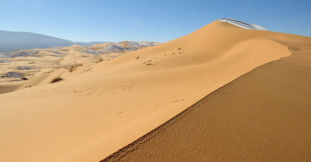 Ice and frost covering sand dunes in the Sahara Desert near Ain Sefra, Algeria.