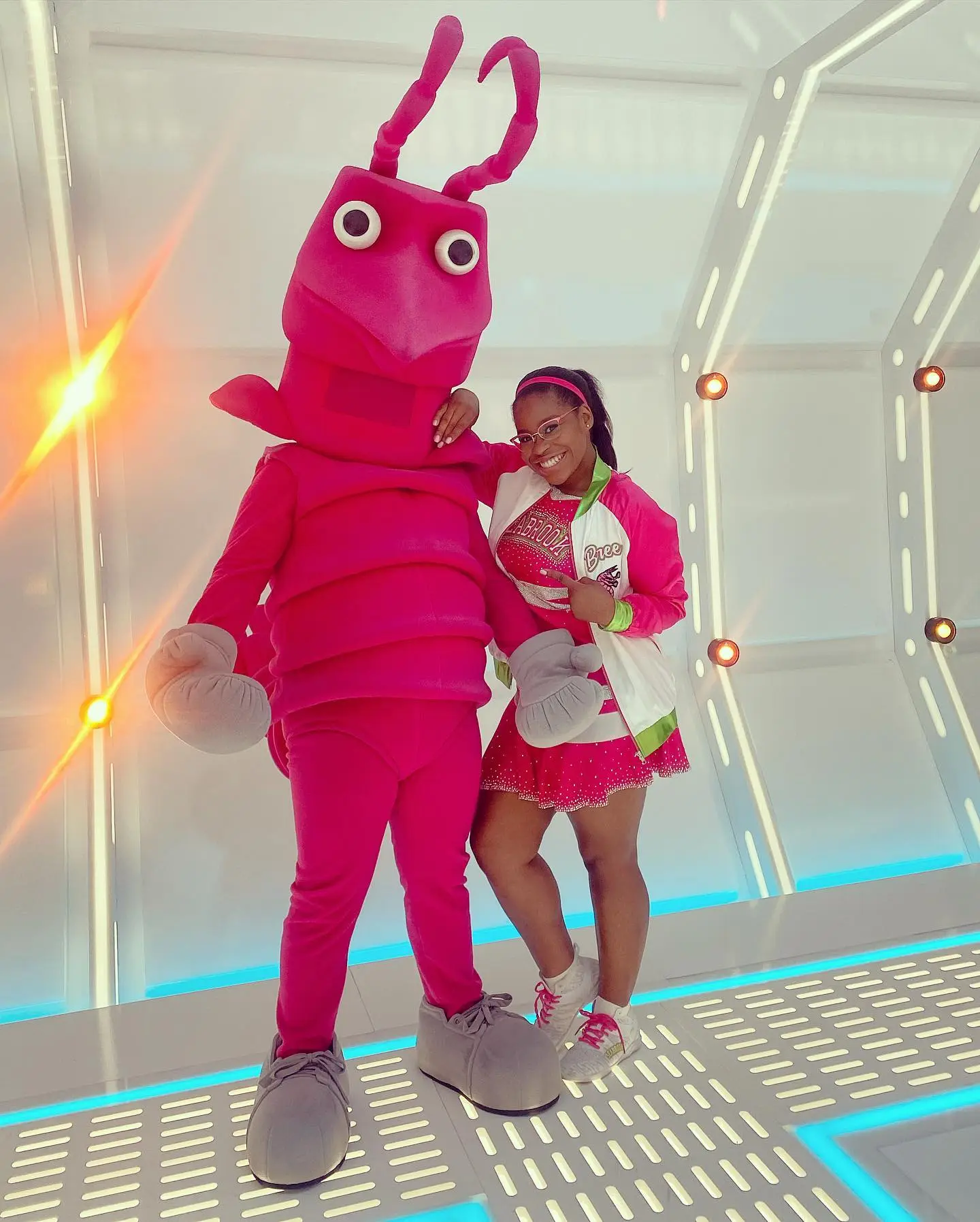 Carla Jeffery posing with a person in a pink insect costume.