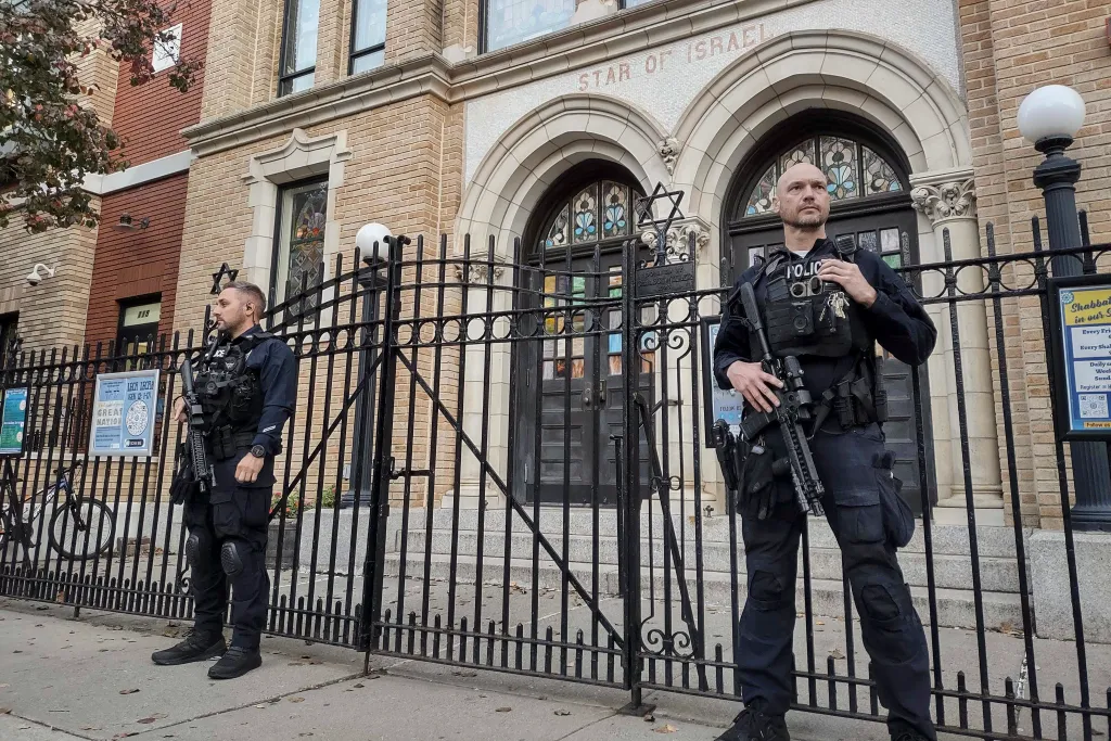 Two police officers stand guard outside the United Synagogue of Hoboken.