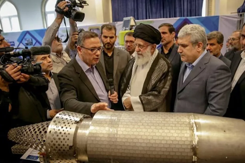 Men gathered around to inspect a missile displayed in a ceremony to deliver Abu Mahdi naval cruise missiles to Iran's national Navy and Revolutionary Guard.
