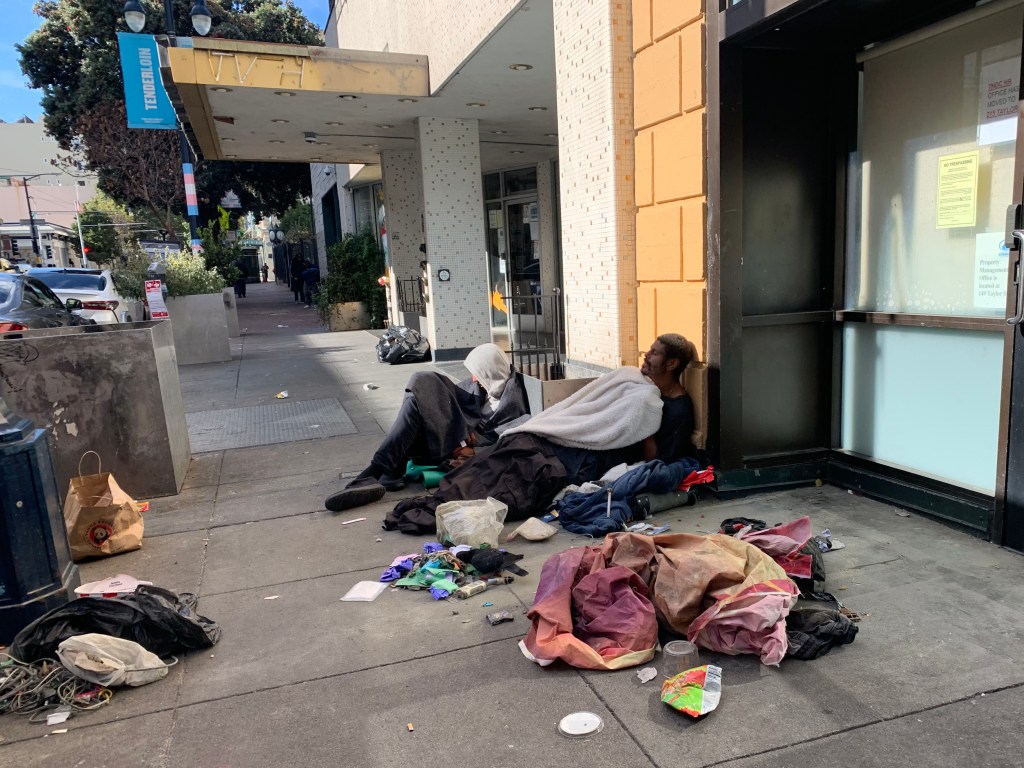 A homeless man sleeps on the street in San Francisco's Tenderloin District.