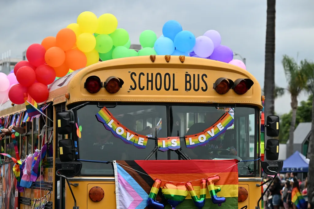 A school bus adorned with rainbow colors and balloons for the LA Pride Parade.