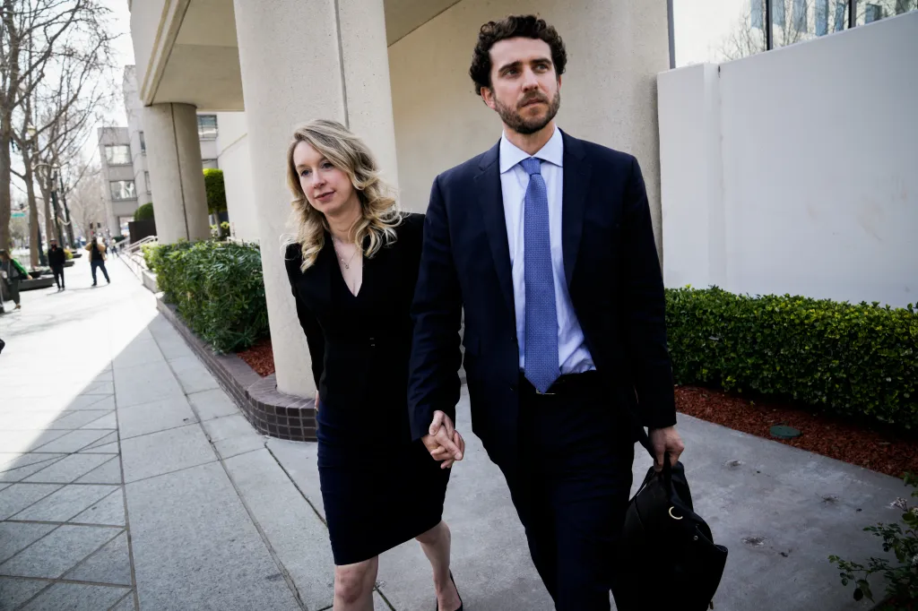 Elizabeth Holmes and Billy Evans walking hand-in-hand outside the Robert E. Peckham U.S. Courthouse.
