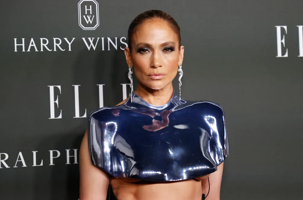Jennifer Lopez poses in a metallic blue sculptural top and dangling diamond earrings.