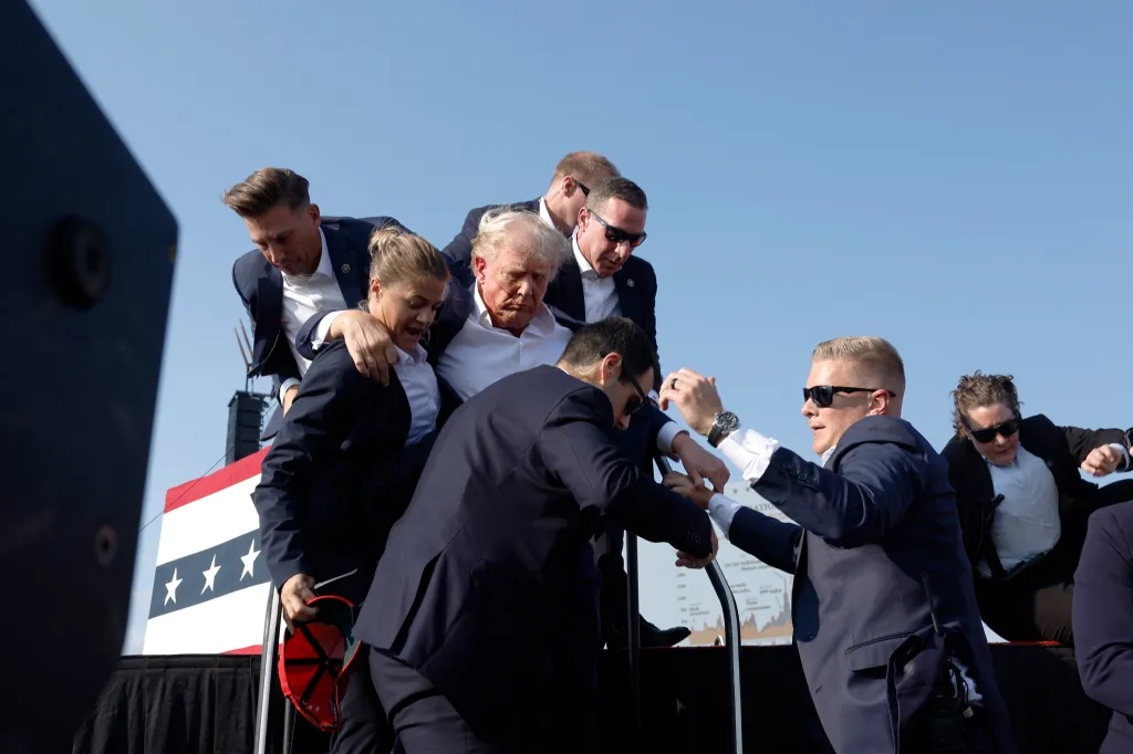 Donald Trump being rushed offstage by Secret Service agents after being injured during a rally.