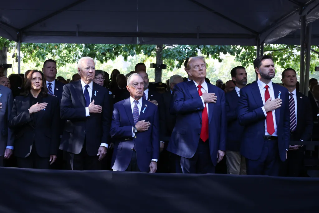 Kamala Harris, Joe Biden, Michael Bloomberg, Donald Trump, and J.D. Vance stand with hands over hearts at a 9/11 memorial.