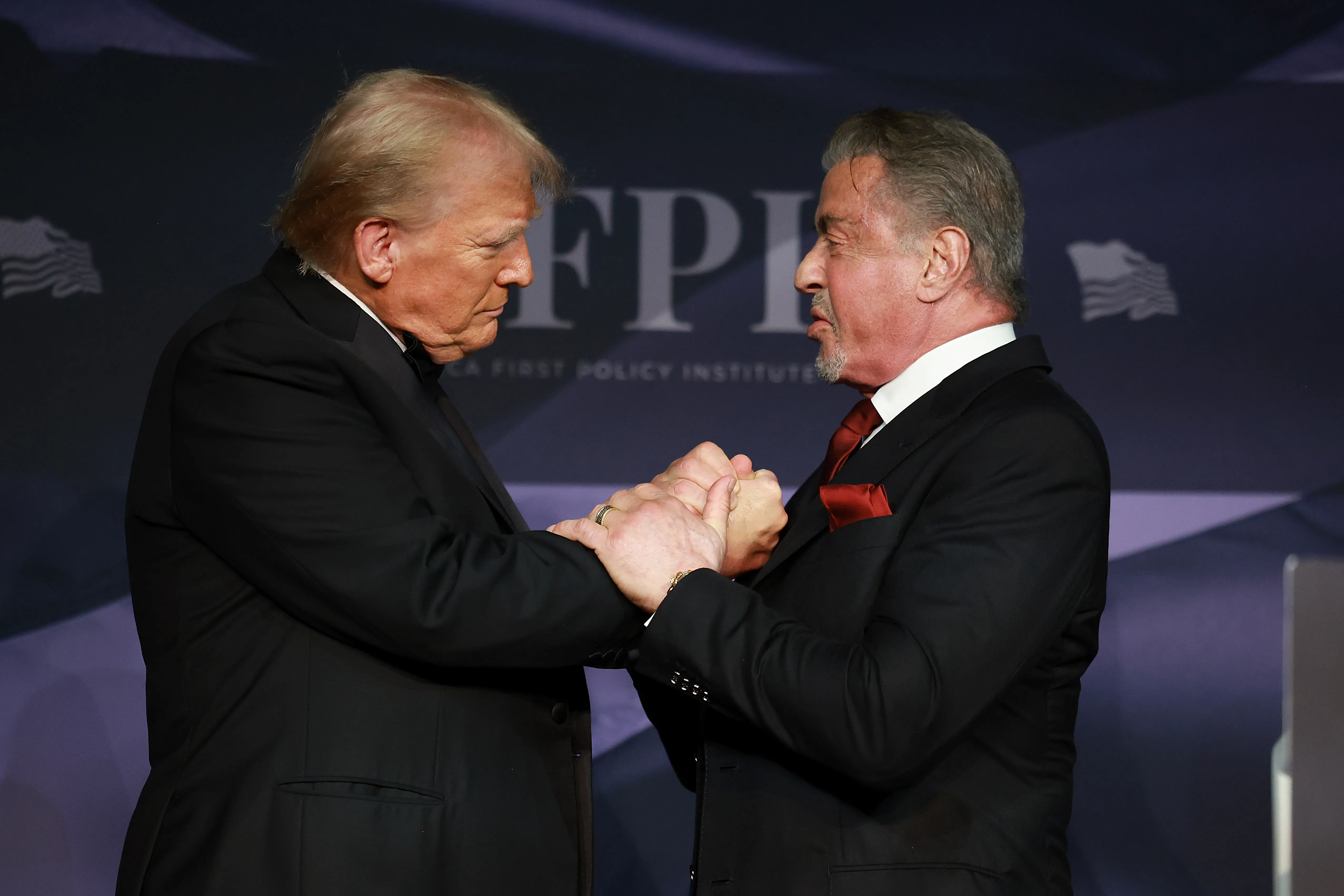 Trump greets actor Sylvester Stallone onstage at the America First Policy Institute Gala held at Mar-a-Lago on November 14, 2024 in Palm Beach, Florida.
