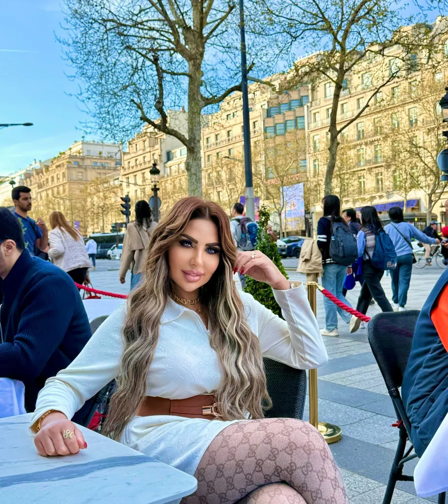 Sarah Khalifa, an Egyptian TV presenter and lifestyle influencer, sitting at a cafe table outdoors.