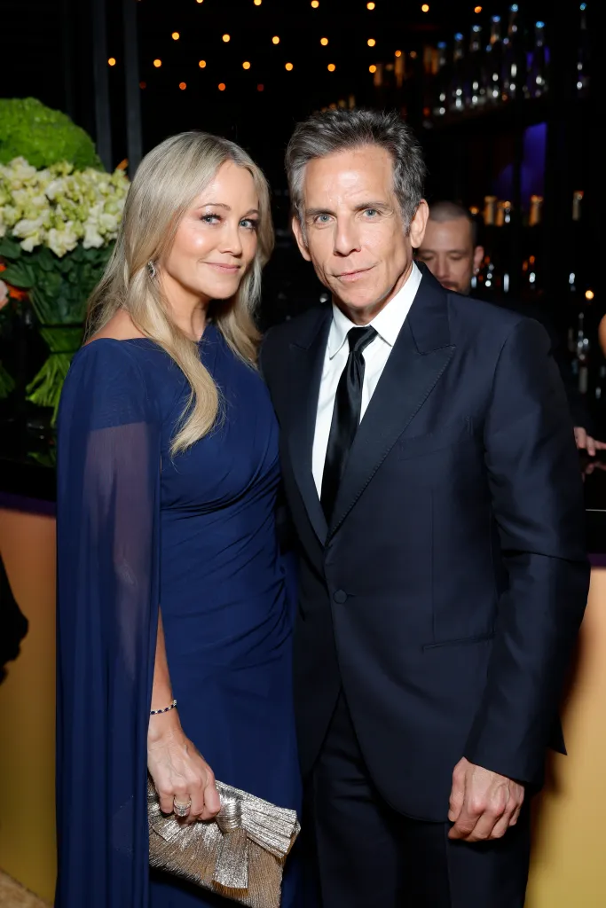Christine Taylor in a navy gown and Ben Stiller in a dark suit pose together.