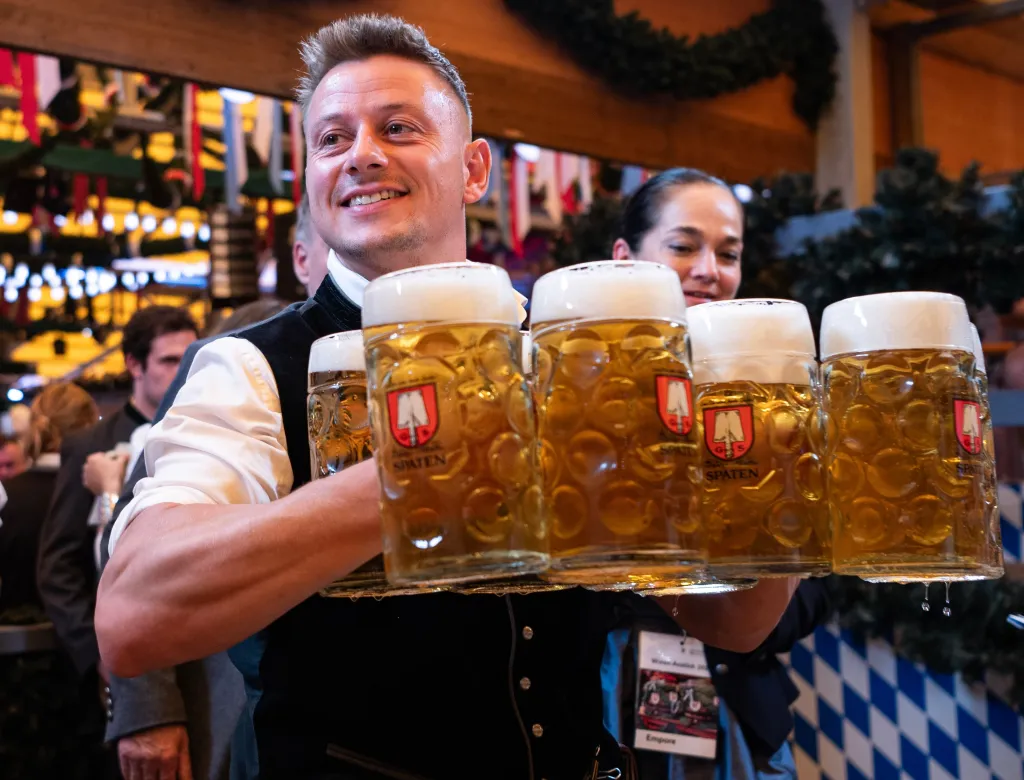 A staff member carries five cups of beer at the Oktoberfest in Munich, Germany.