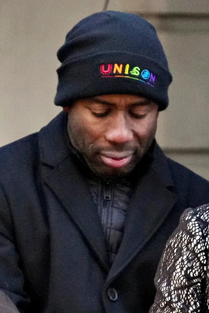 Former New York Mayor Eric Adams looking down, wearing a black beanie with