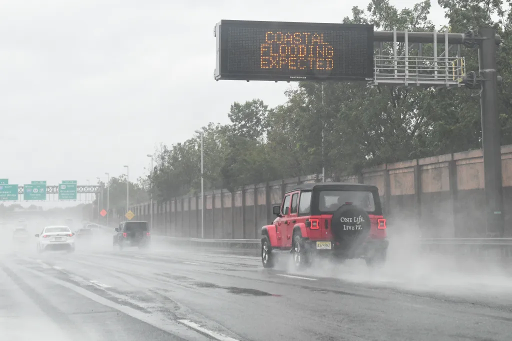 A car passes under a sign warning of expected coastal flooding during a major nor'easter near Atlantic City, New Jersey.