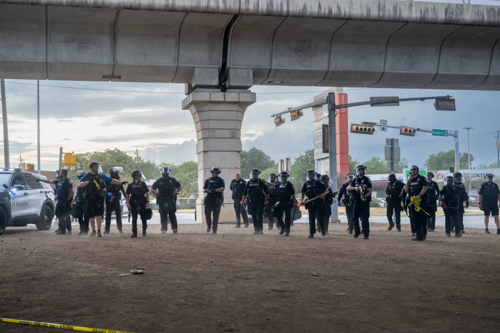 Law enforcement officers retreat as people protest against Immigration and Customs Enforcement (ICE) officers on Sunday in Austin, Texas.