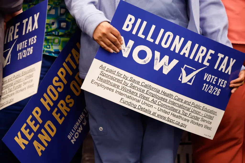 Two protesters hold signs advocating for the 