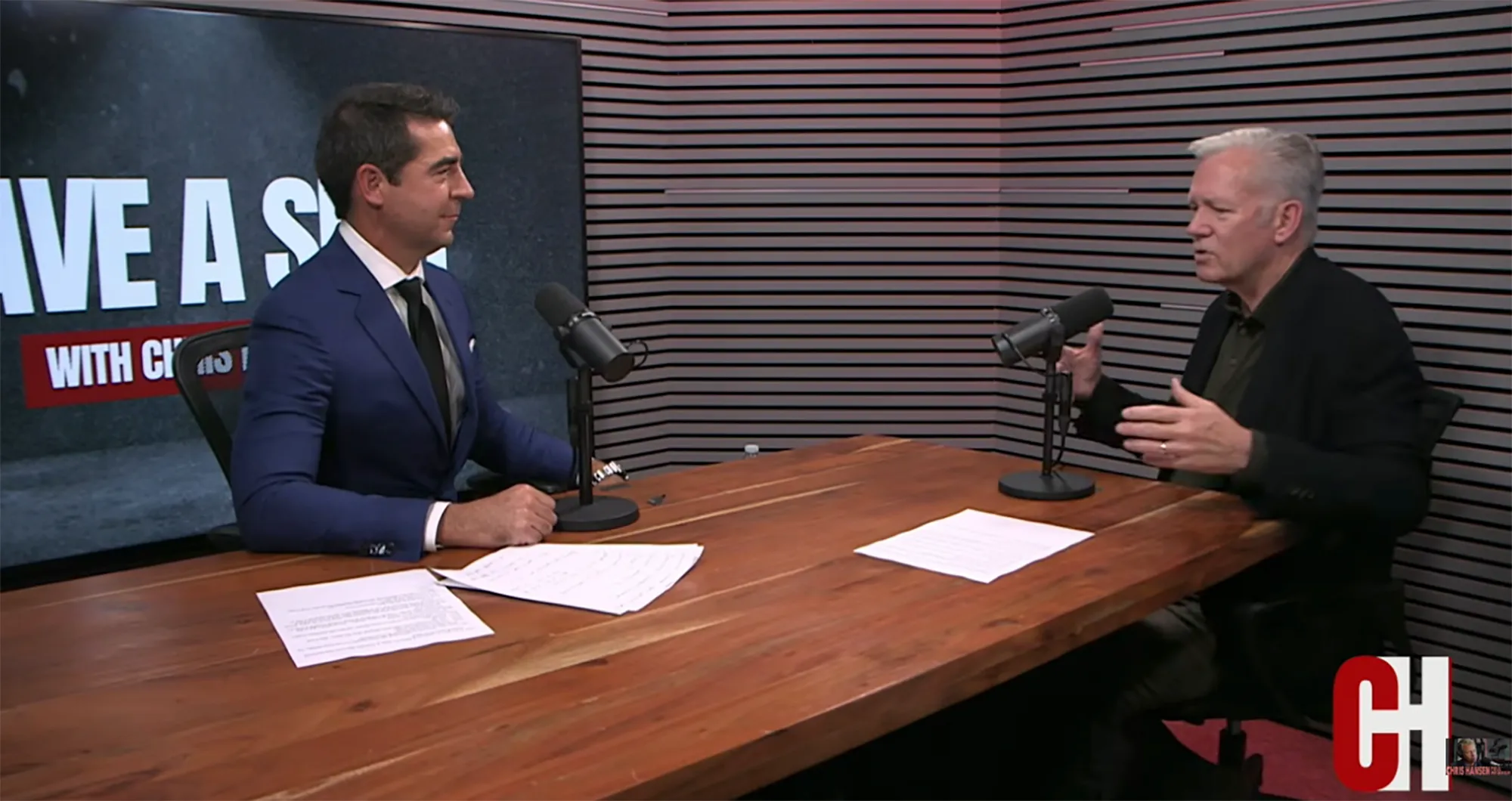 Chris Hansen interviewing a man at a table with microphones.