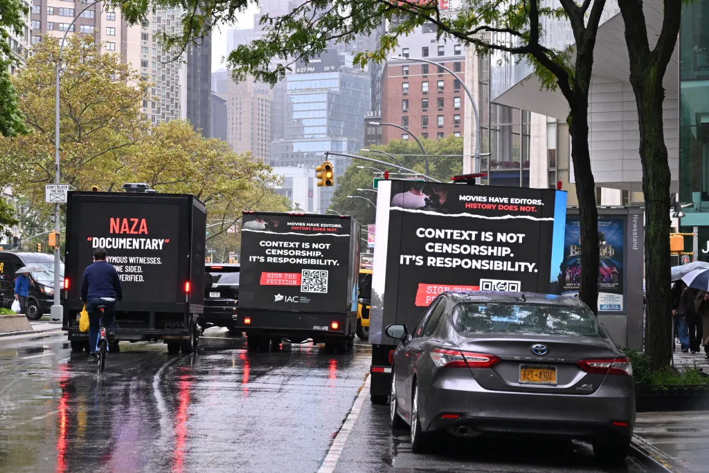 Three trucks with large video screens displaying messages about the