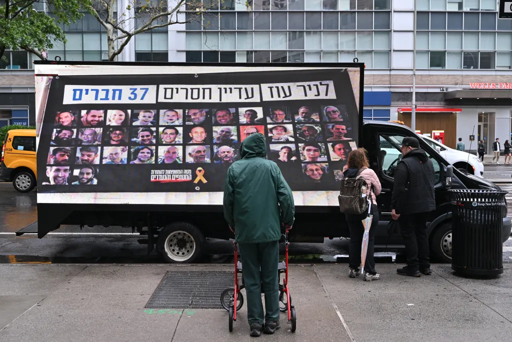 A truck displaying photos of 37 missing people with text in Hebrew that reads