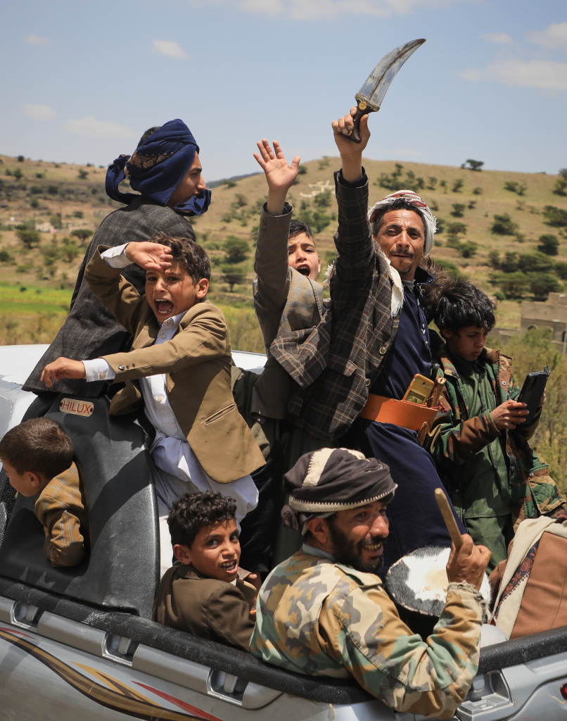 Yemeni civilians celebrating and riding in the back of a pickup truck in the Bani Matar district, Yemen.