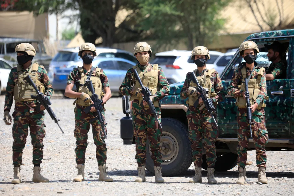 Houthi forces patrol Sana'a in camouflage uniforms, masks, helmets, and armed with rifles.