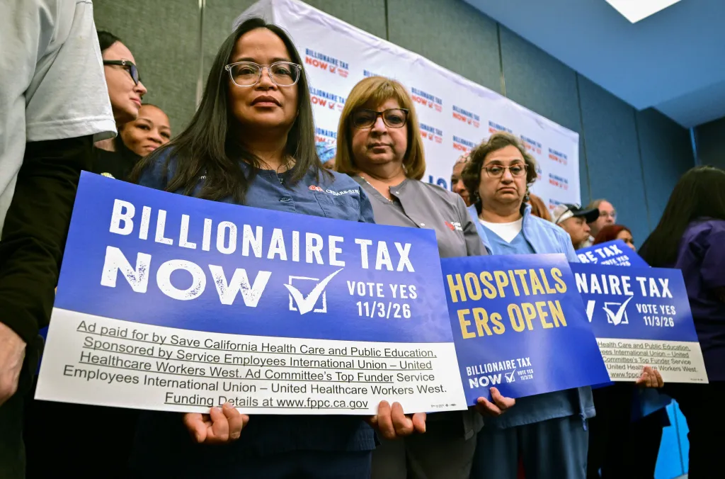 Healthcare workers and allies hold signs reading