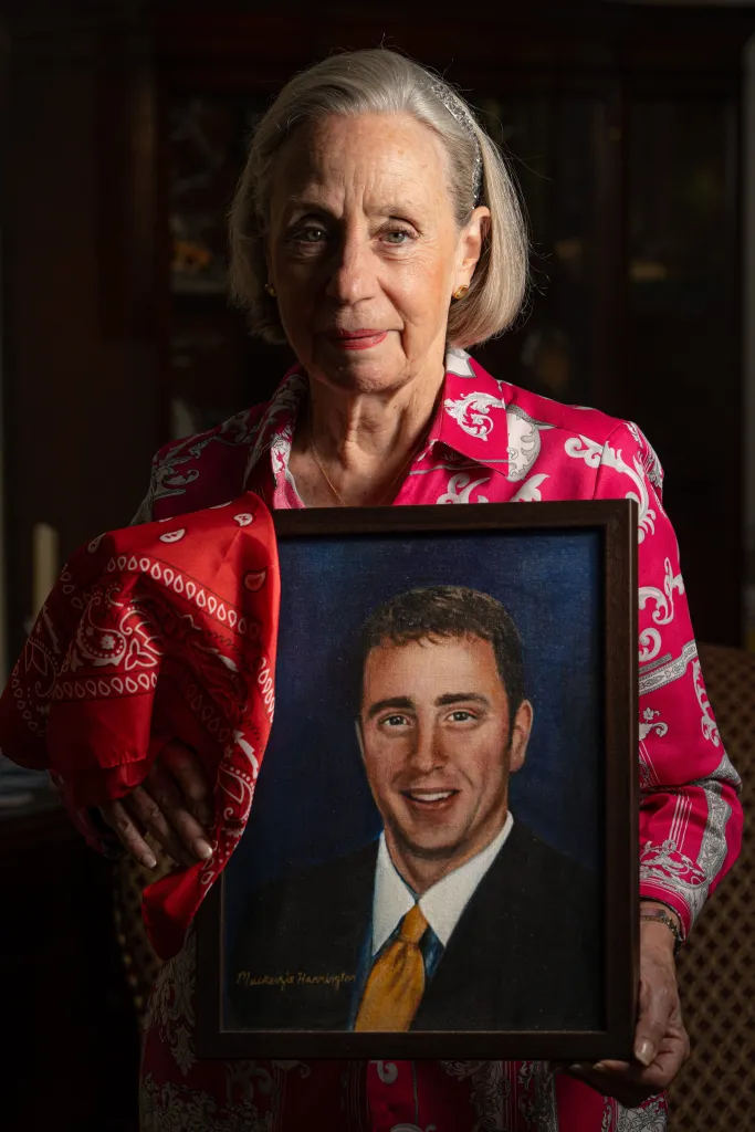 Alison Crowther holding a painting of her son Welles Crowther and a red bandana.
