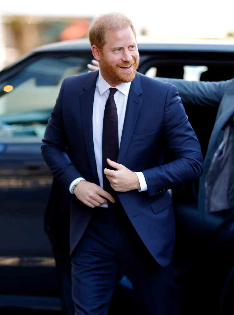 Prince Harry, Duke of Sussex, smiles as he exits a car.