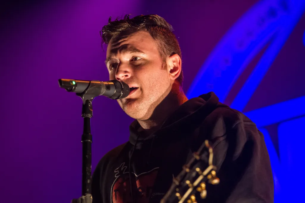 Chad Gilbert of New Found Glory singing into a microphone.