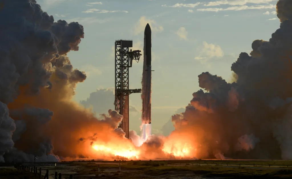The SpaceX Starship and Super Heavy v3 Booster lifting off with flames and smoke.