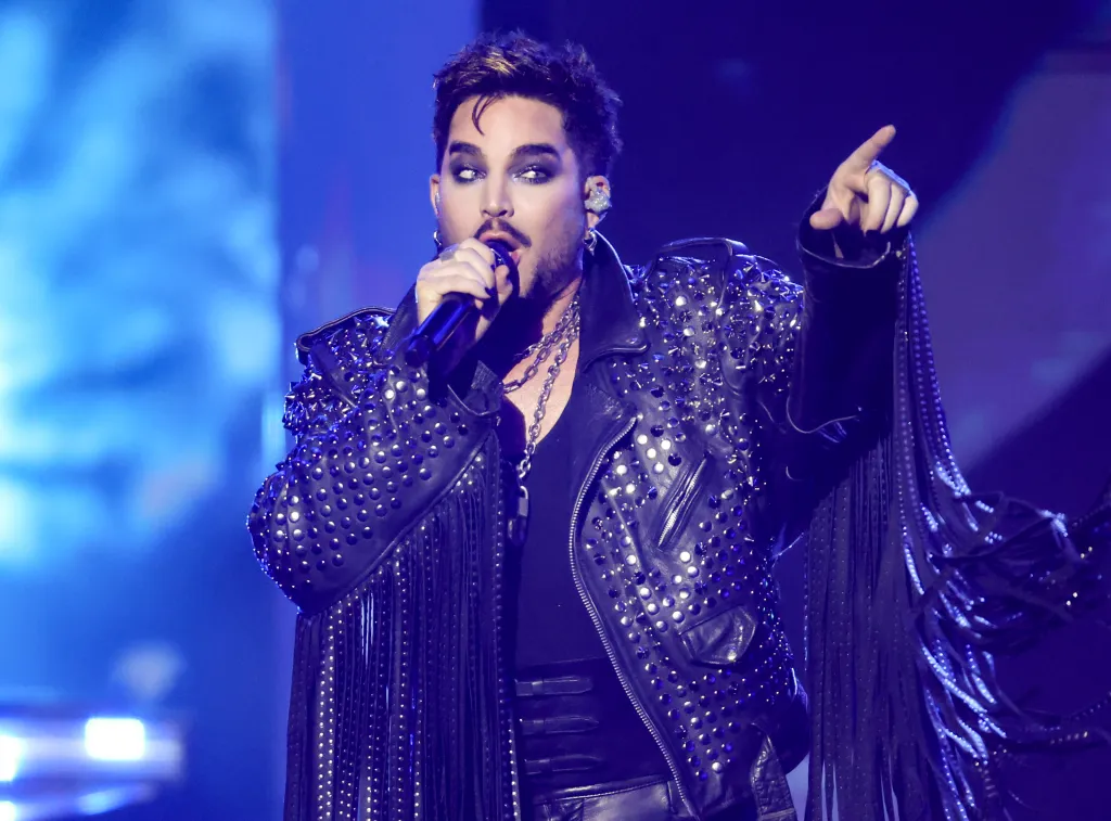 Adam Lambert performing onstage in a studded leather jacket.