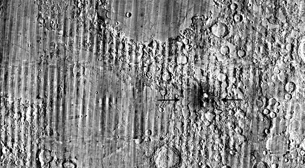 Black and white image of the Moon's surface with many craters and a new crater, named 