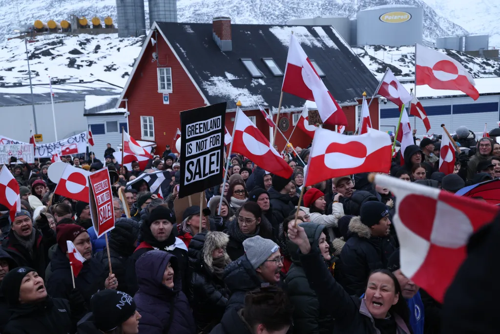 People in Nuuk, Greenland, protest the U.S. intent to acquire Greenland, holding Greenlandic flags and signs that say 