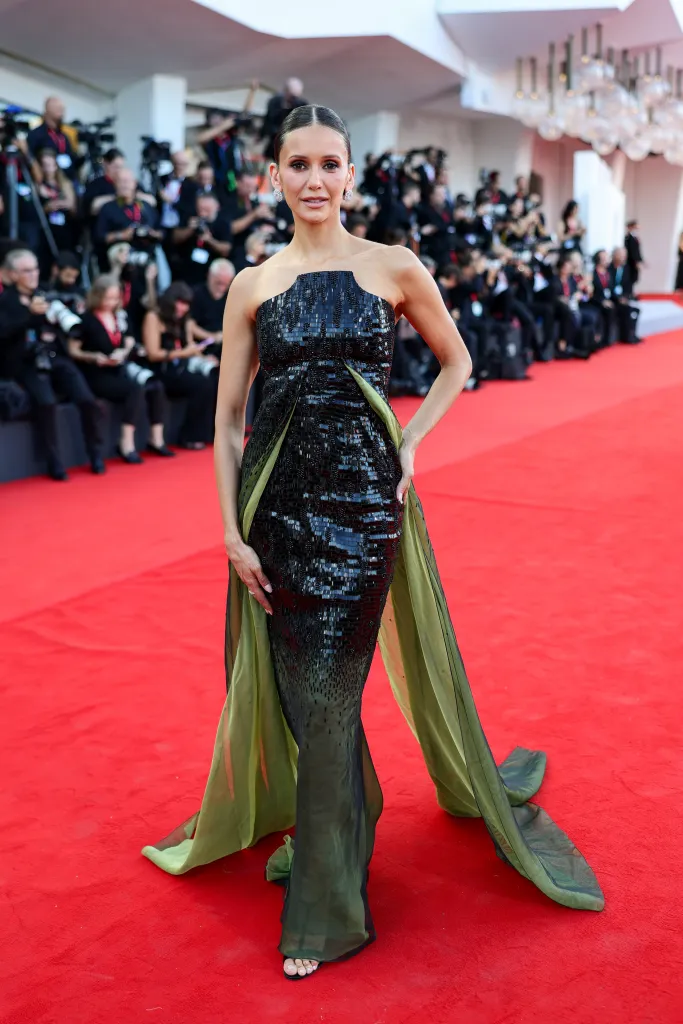 Nina Dobrev in a black and green strapless gown on the red carpet at the Venice Film Festival.