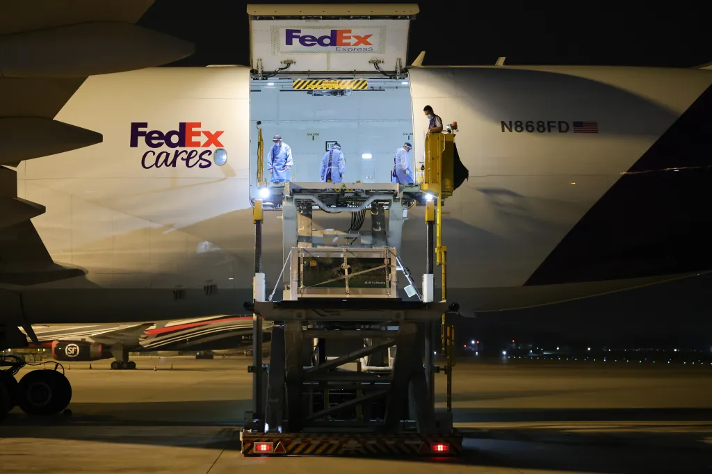 A crate containing a panda is loaded onto a FedEx airplane at night.