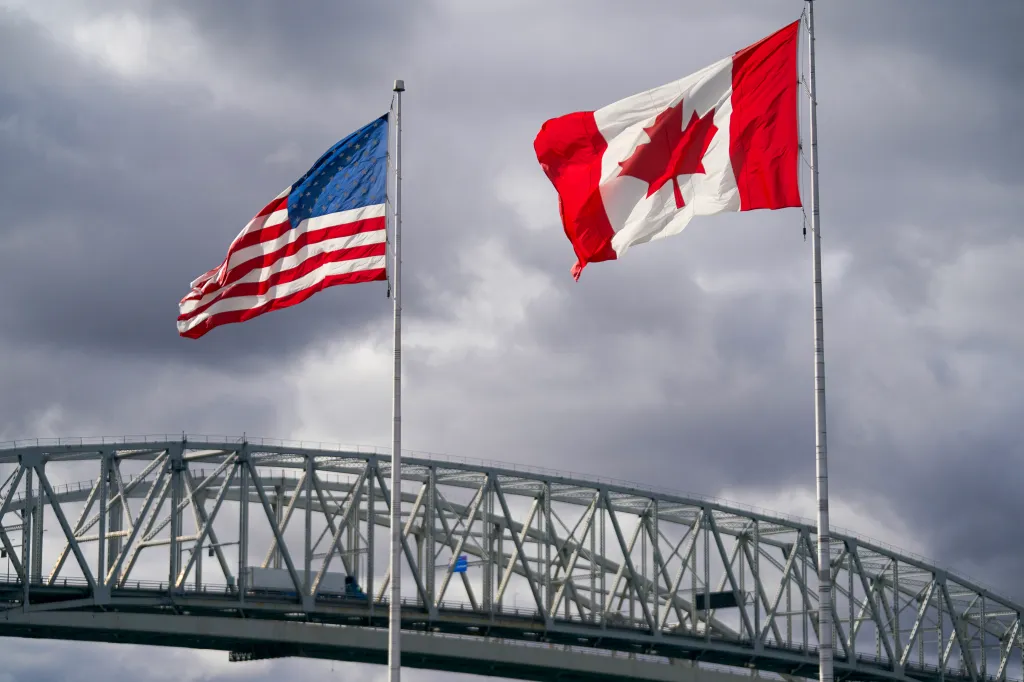 US and Canadian flags fly above the Blue Water Bridge border crossing.