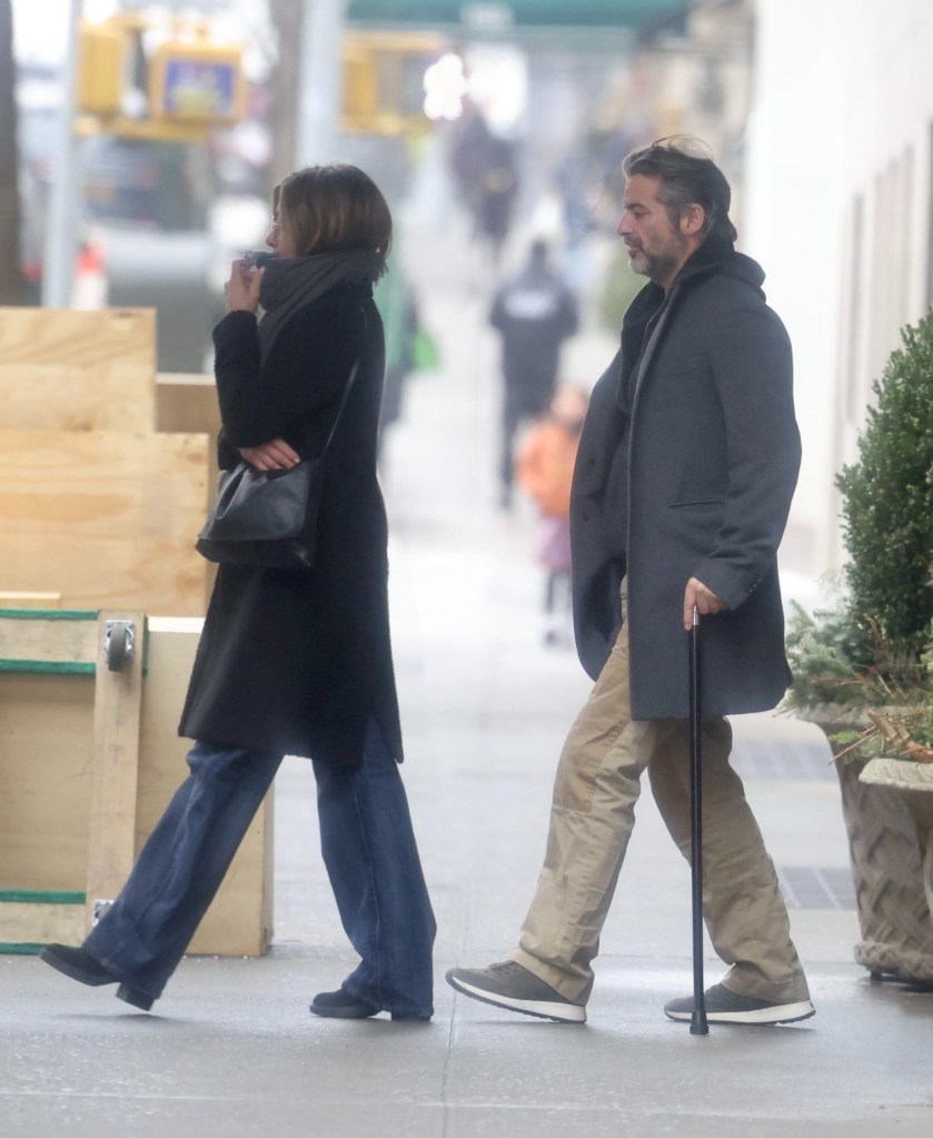 Jennifer Aniston and Jim Curtis walking on a street in New York City.
