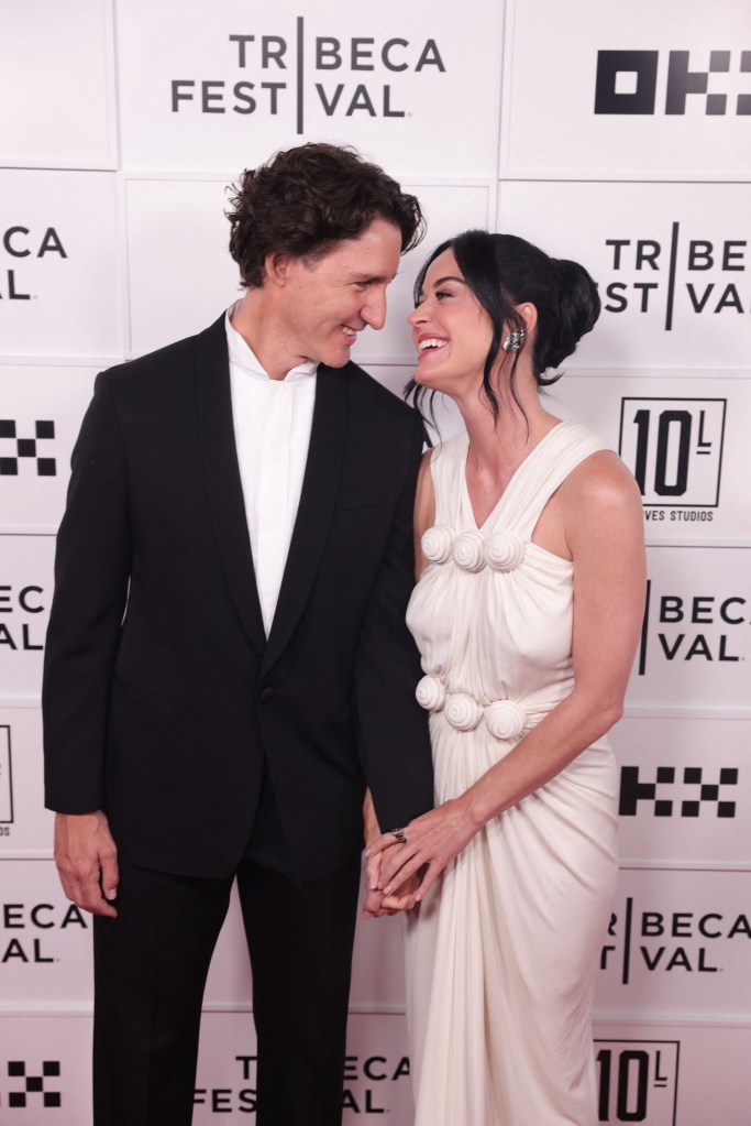 Katy Perry and Justin Trudeau holding hands and smiling at each other at the Tribeca Festival premiere.
