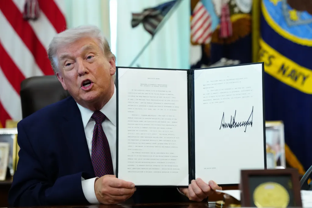 President Trump displays a signed executive order in the Oval Office of the White House in Washington, DC, on Tuesday, March 31, 2026. 