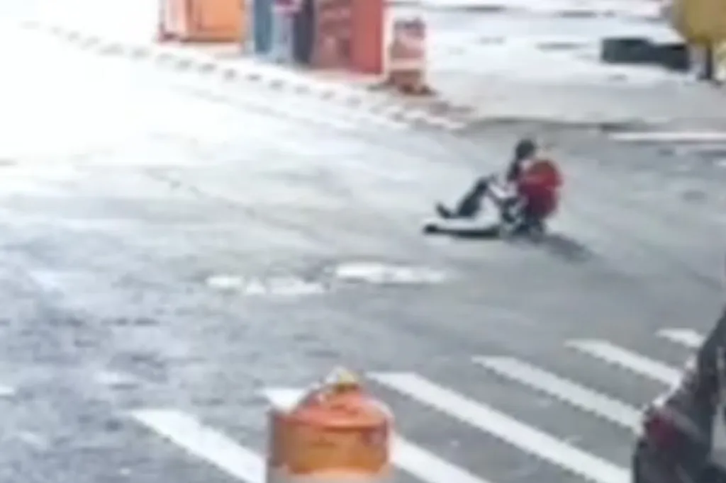 Two individuals emerging from a manhole on a street in Williamsburg, New York.