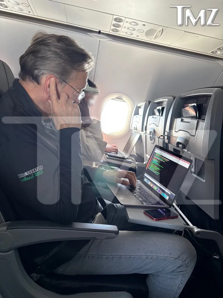 Jim Thornton working on a laptop on an airplane.