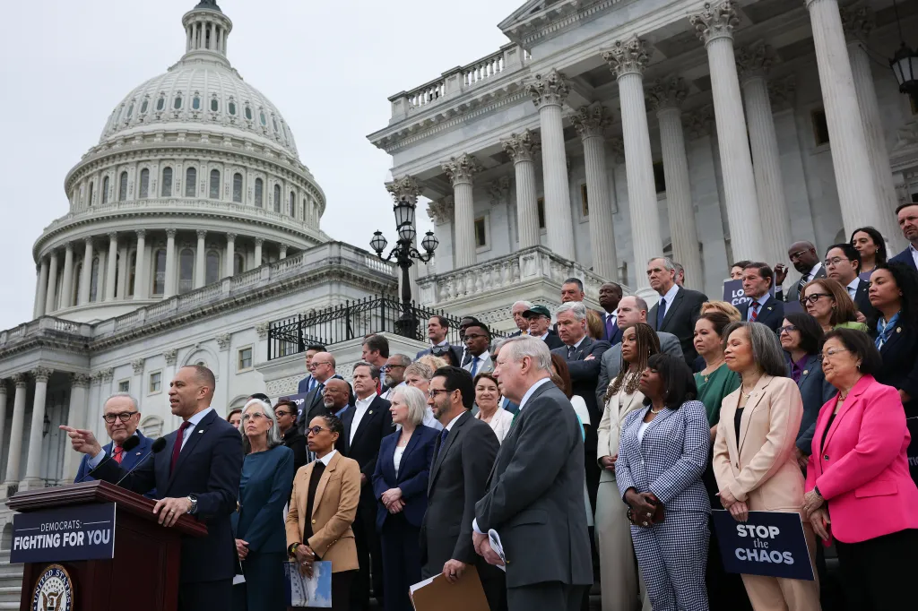 House Democratic Leader Hakeem Jeffries speaks at a podium with Senate Democratic Leader Chuck Schumer and other Democrats on the steps of the U.S. Capitol.